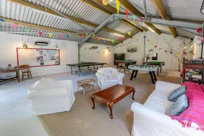 a living room with white furniture and ping pong tables at 3 Bed in Launceston oc-l31001 in Lewannick