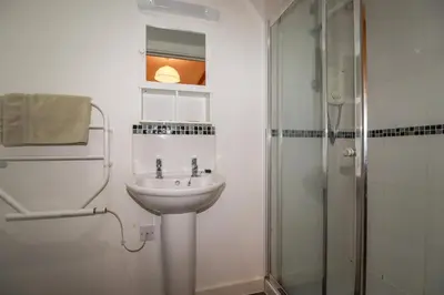 a white bathroom with a sink and a shower at Trenethick in Truro
