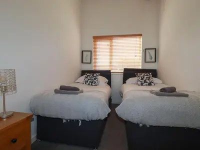 a bedroom with two twin beds and a window at Trenethick in Truro