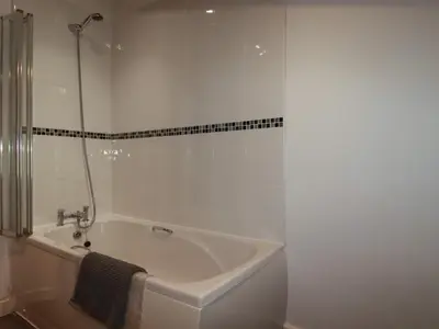 a white bathroom with a tub and a shower at Trenethick in Truro