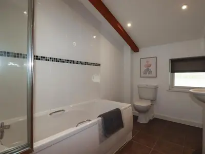 a bathroom with a bath tub and a toilet at Trenethick in Truro