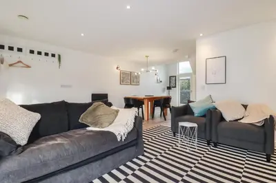 a living room with two couches and a dining room at Treveglos in Truro