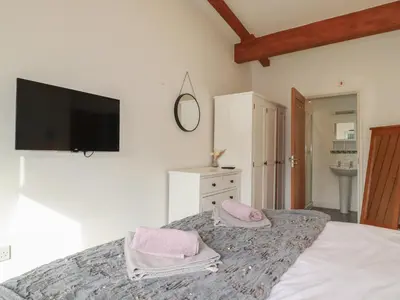 a bedroom with a bed with pink towels on it at Treveglos in Truro