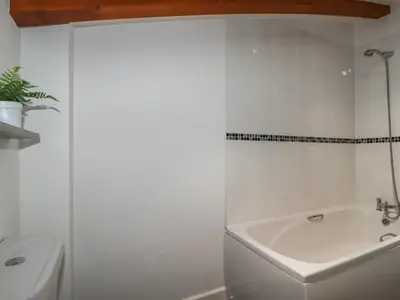 a white bathroom with a tub and a sink at Treveglos in Truro