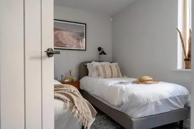 a bedroom with two beds and a picture on the wall at 3 Bedroom Luxury Waterside House in Hayle