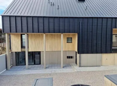 a large building with a black roof and a courtyard at 3 Bedroom Luxury Waterside House in Hayle