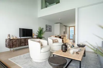 a living room with two white chairs and a table at 3 Bedroom Luxury Waterside House in Hayle