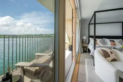 a bedroom with a view of the water at 3 Bedroom Luxury Waterside House in Hayle