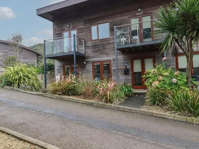 a house with a balcony on the side of a street at Tregullan in Truro