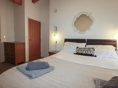 a bedroom with a large bed with a blanket on it at Tregullan in Truro