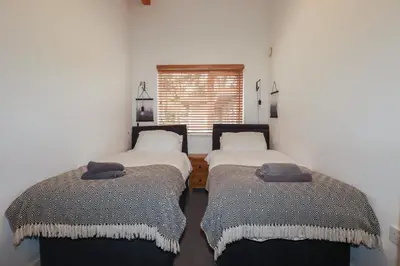 two twin beds in a room with a window at Tregullan in Truro