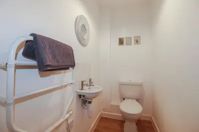 a small bathroom with a toilet and a sink at Tregullan in Truro