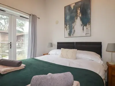 a bedroom with a large bed and a window at Treburgett in Truro