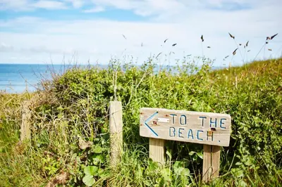 a sign that says to the beach on a fence at St Moritz Hotel Houses in Polzeath