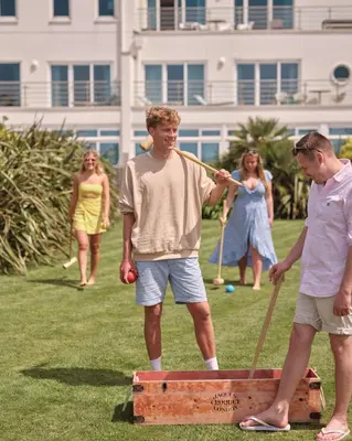 two men playing a game of croquet in a park at St Moritz Hotel Houses in Polzeath
