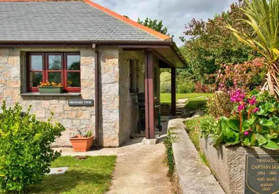 a small stone building with a sign in front of it at Finest Retreats - Orchard View in Hayle
