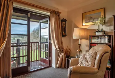 a living room with a chair and a sliding glass door at Finest Retreats - Orchard View in Hayle