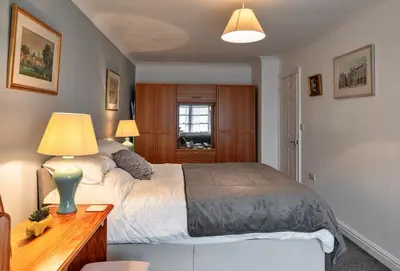 a bedroom with a bed and a desk with a lamp at Finest Retreats - Orchard View in Hayle