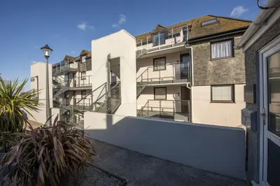 an apartment building with balconies and plants at Pink Sands, Carrack Widden, St Ives in St Ives