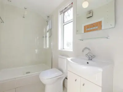 a white bathroom with a toilet and a sink at 1 Atlantic View in Newquay