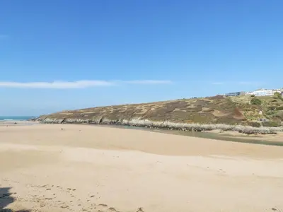 a view of a beach with a hill in the background at 1 Atlantic View in Newquay