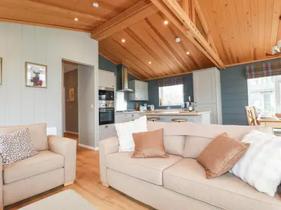 a living room with a couch and a kitchen at 6 Meadow Retreat in Liskeard