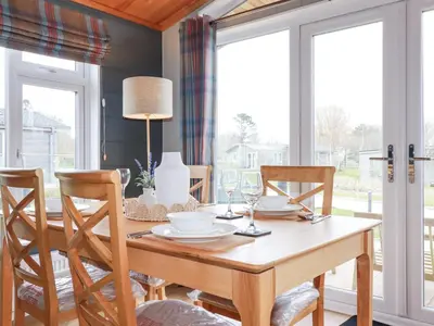 a dining room with a wooden table and chairs at 6 Meadow Retreat in Liskeard
