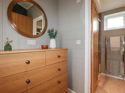 a bathroom with a dresser and a mirror at 6 Meadow Retreat in Liskeard