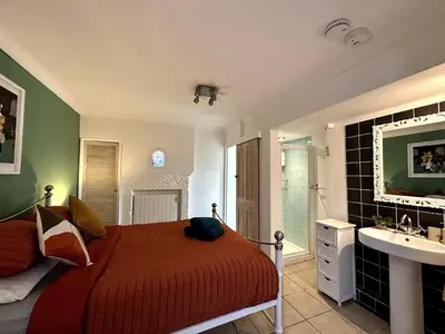 a bedroom with a bed and a bathroom with a sink at 'Rocks' Sea Views with free parking in St Ives in St Ives