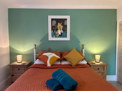 a bedroom with a bed with a blue wall at 'Rocks' Sea Views with free parking in St Ives in St Ives