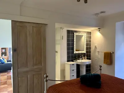 a bedroom with a bed and a sink and a mirror at 'Rocks' Sea Views with free parking in St Ives in St Ives