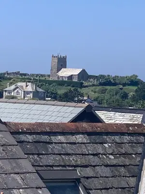 a group of roofs with a castle in the background at First-Floor Georgian Apartment with Terrace and Sea Views in Boscastle in Boscastle