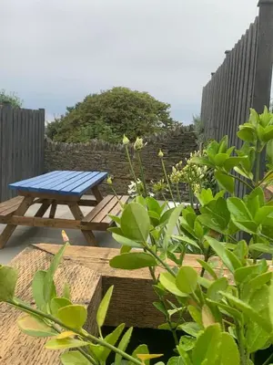 a picnic table and a bench in a garden at First-Floor Georgian Apartment with Terrace and Sea Views in Boscastle in Boscastle