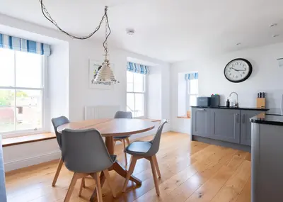 a kitchen and dining room with a table and chairs at First-Floor Georgian Apartment with Terrace and Sea Views in Boscastle in Boscastle