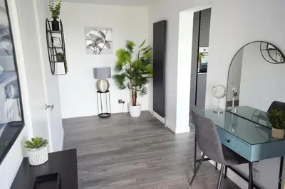 a dining room with a glass desk and plants at Riverview Modern 2 Bed- Parking & Tesla charger in Penryn