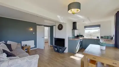 a living room and kitchen with a couch and a table at G17 St Meva, Riviere Towans in Hayle