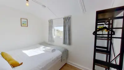 a small bedroom with a bed and a ladder at G17 St Meva, Riviere Towans in Hayle