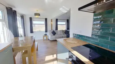 a kitchen and living room with a table and a couch at G17 St Meva, Riviere Towans in Hayle