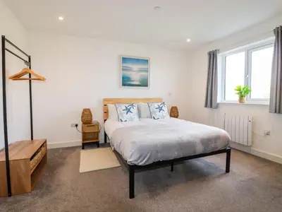 a bedroom with a large bed and a window at Jacana in Perranporth