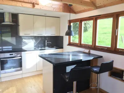 a kitchen with a black counter and some windows at Seaview Studio in Forrabury