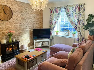 a living room with a couch and a tv at Issys Cottage in Helston