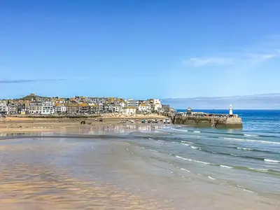 a view of a beach with a town and the ocean at Issys Cottage in Helston