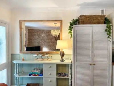 a dressing table with a lamp and a mirror at Issys Cottage in Helston