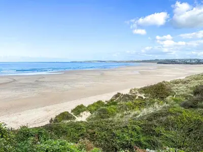 an empty beach with the ocean in the background at Issys Cottage in Helston