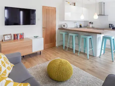 a kitchen with blue stools and a kitchen counter at Chlobo Cottage in Porth