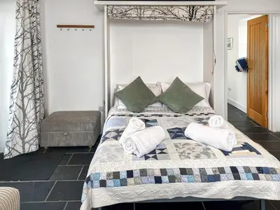 a bedroom with a bed with towels on it at The Milking Parlour in St Ives