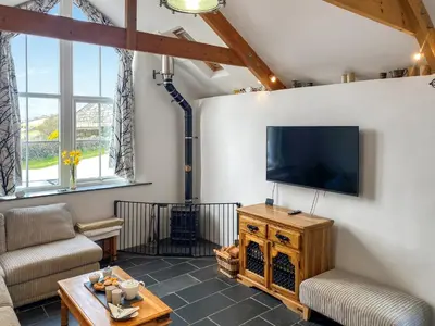 a living room with a flat screen tv on a wall at The Milking Parlour in St Ives