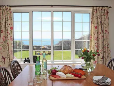 a table with a plate of food and a window at Watchtower in Torpoint