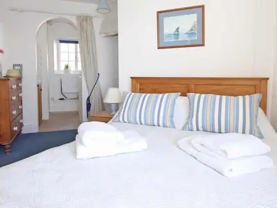 a bedroom with a white bed with two towels on it at Watchtower in Torpoint