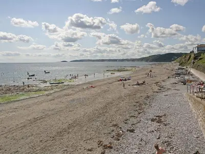a beach with a bunch of people in the water at Watchtower in Torpoint